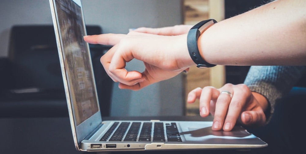 Two people working at a laptop