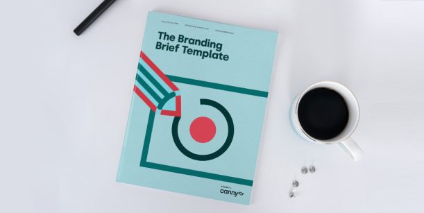 The Branding Brief Template on a desk beside a cup of coffee