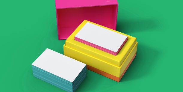 pink, yellow, and blue business cards on green background
