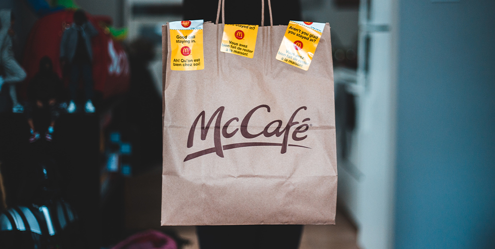 Person holding a paper McCafe bag