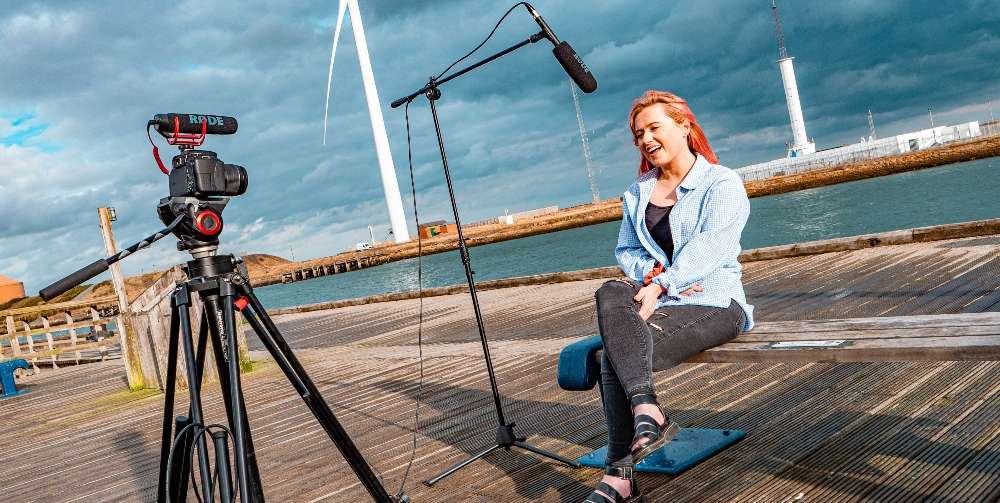 woman sat outside in front of camera