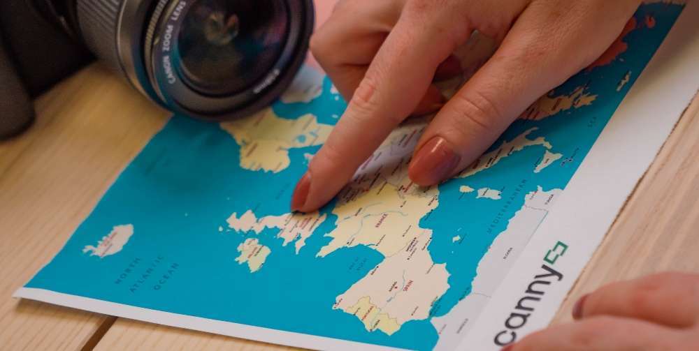 person pointing at a map with a camera in the background