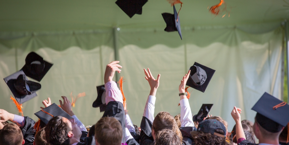students throwing caps in the air