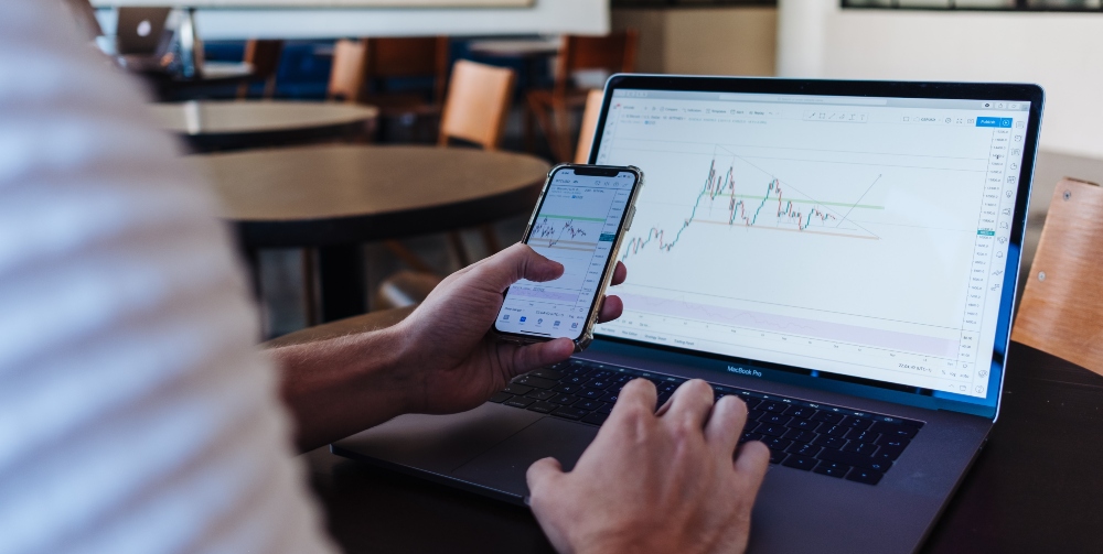 man on laptop with graph on screen