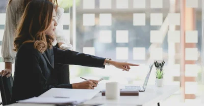 Woman pointing at a laptop.
