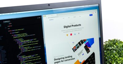 A computer screen showing code on one side and a website design on the other