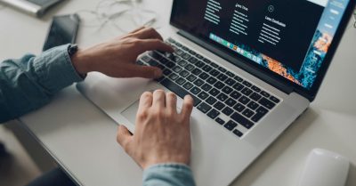 Hands shown typing on a laptop.