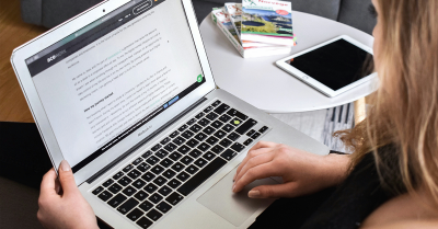 Person writing a piece of content on a laptop.